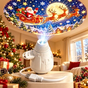Könnte beinhalten: Ein weißer, kuppelförmiger Weihnachts-Projektor mit USB-Stromkabel. Das Gerät projiziert ein kreisförmiges Bild an die Decke, das den Weihnachtsmann in einem roten Schlitten mit Rentieren, einen Vollmond, Sterne und ein verschneites Dorf zeigt.