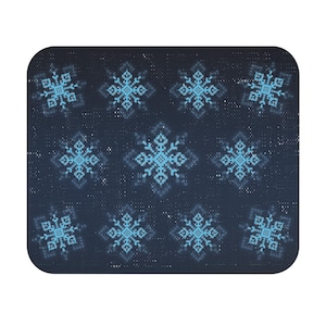 May include: A rectangular mouse pad with rounded corners featuring a dark navy blue background covered in a repeating pattern of light blue pixelated snowflakes and small white dots scattered across the surface.