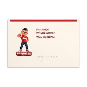 Könnte beinhalten: Eine rechteckige Postkarte mit cremefarbenem Hintergrund und rotem oberen Rand. Sie zeigt eine Comicfigur, die nach vorne zeigt und ein rotes T-Shirt mit weißem Kronenmotiv, blaue Jeans und rote Sneaker trägt. Text: FRANKEN. WENIG WORTE. VIEL MEINUNG. WUTFRANKE OLLI. BASSD SCHO. Liebe Grüße aus Franken. Bassd scho.