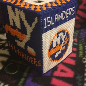 May include: A blue and white tissue box cover with orange accents. The cover features the New York Islanders logo and the words "NY Islanders".