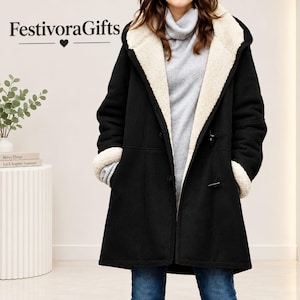 Può includere: Un cappotto nero con fodera in ecopelliccia color crema, un ampio cappuccio e chiusure a alamaro. Il cappotto è indossato sopra un maglione a collo alto grigio chiaro e jeans blu. Il testo FestivoraGifts è visibile nell'angolo in alto a sinistra.