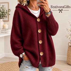 May include: A deep burgundy hooded cardigan featuring a ribbed knit texture, long sleeves with ribbed cuffs, and four large, light-coloured wooden buttons down the front. The text FestivoraGifts is visible in the upper right corner.