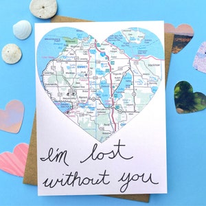 May include: A white card with a heart-shaped map of a region with the text "I'm lost without you" written in black cursive.