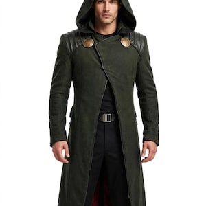 May include: A dark olive green long coat featuring an attached hood, black leather-like shoulder panels with ribbed detailing, and two large circular gold-toned buttons at the chest. The coat has an asymmetrical front closure and a dark red lining.