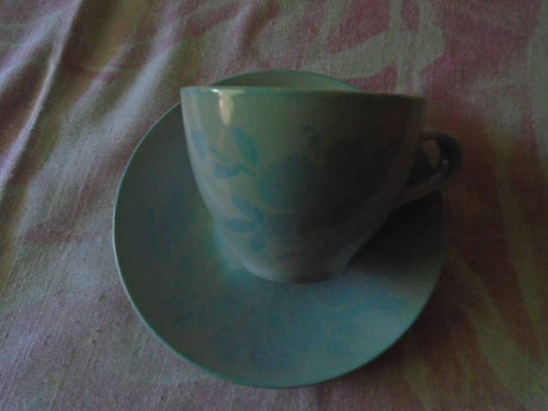 May include: A blue and white floral teacup and saucer set. The cup has a handle and a floral design. The saucer is plain blue.