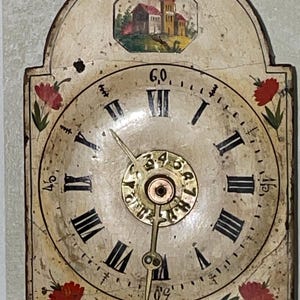 May include: Antique wall clock with a cream-colored face and black Roman numerals. The clock features a painted landscape scene at the top and red floral accents. The clock hands are gold-colored.