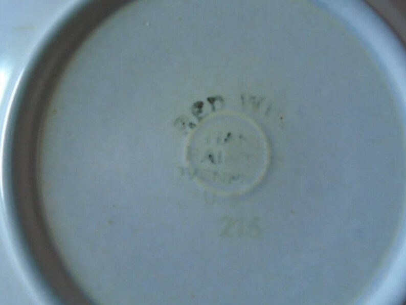 May include: A white ceramic plate with a blue and green mark that reads "Red Wing USA Z16".