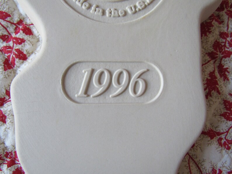 Puede incluir: Adorno de cer&aacute;mica blanca con el a&ntilde;o 1996 en relieve.