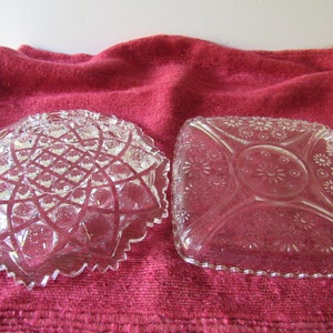 K&ouml;nnte beinhalten: Zwei durchsichtige Glasschalen mit aufwendigen Schnitzereien. Die Schale links hat ein geometrisches Muster, w&auml;hrend die Schale rechts ein Blumenmuster hat.