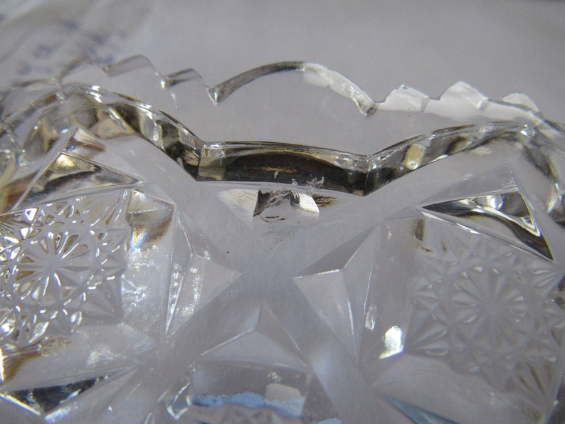 K&ouml;nnte beinhalten: Eine klare Glassch&uuml;ssel mit geschnittenem Glasdesign. Die Sch&uuml;ssel hat einen gewellten Rand und ein Sternenmuster.