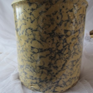 May include: A vintage, yellow and blue, glazed ceramic crock with a mottled pattern.