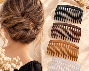 May include: A set of four curved hair combs in black, dark brown, light brown, and clear plastic. Each comb features a series of long, slender teeth designed to secure hair in place. The combs are arranged vertically in a row on a flat surface.