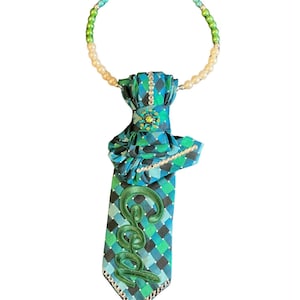 Blauw en groen geruit patroon met God-patch en veelkleurige parelketting.