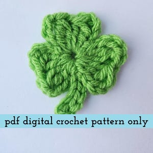May include: A bright green, crocheted shamrock with three leaves, set against a white background. The text "pdf digital crochet pattern only" is displayed in a light blue banner below the shamrock. This handmade item is perfect for St. Patrick's Day.