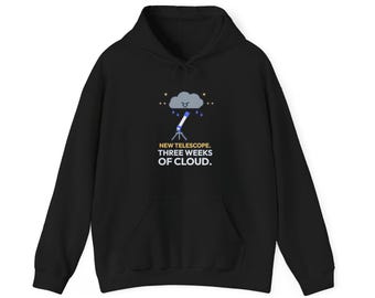 May include: A black hooded sweatshirt featuring a graphic of a telescope pointed at a grumpy grey rain cloud. Below the graphic, the text reads: NEW TELESCOPE. THREE WEEKS OF CLOUD. The design includes small yellow stars and blue raindrops.