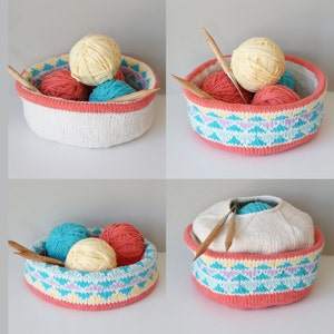 May include: A white knitted basket with a colourful geometric pattern around the top. The basket is filled with balls of yarn in various colours, including yellow, red, and blue. The basket is sitting on a white surface.