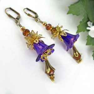May include: Purple glass flower earrings with gold filigree accents and brown glass beads.