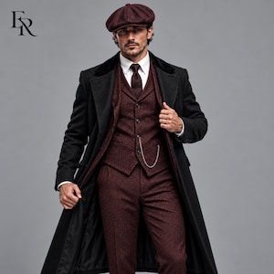 May include: A dark burgundy tweed three-piece suit consisting of a vest, trousers, and a matching flat cap. The suit is worn with a white collared shirt, a dark tie, and a long black overcoat with a velvet collar and a silver pocket watch chain.