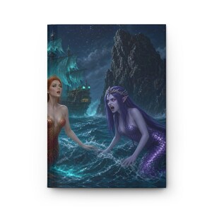 May include: A hardcover journal featuring a fantasy illustration of two mermaids in a dark ocean at night. One mermaid has red hair and a gold tail, while the other has purple hair, a purple tail, and a crown. A large ship sails in the background.