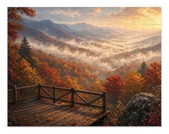 May include: A jigsaw puzzle depicting a wooden deck with a railing overlooking a mountain valley during autumn. The scene features vibrant orange and red trees, rolling hills partially obscured by morning mist, and a golden sunrise.