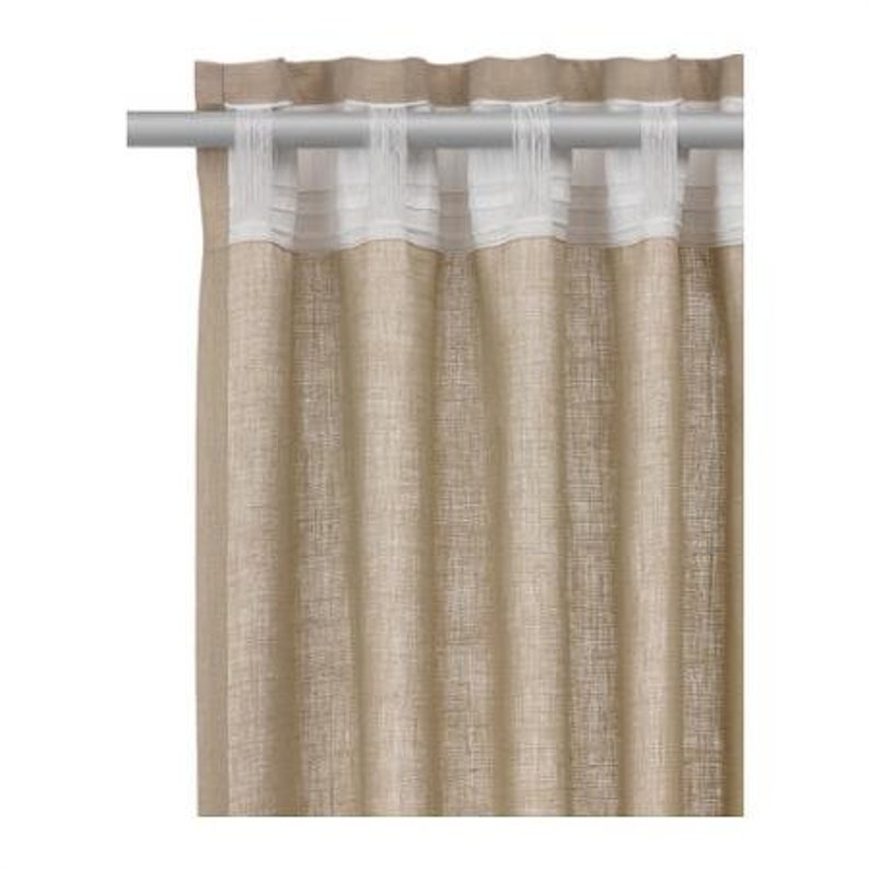 May include: A pair of beige linen curtains with a white ruffled trim at the top. The curtains are hanging from a silver curtain rod.