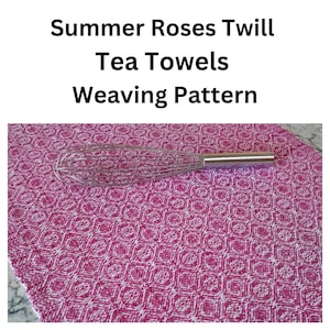 May include: A pink and white patterned tea towel with the text "Summer Roses Twill Tea Towels Weaving Pattern." A stainless steel whisk rests on the towel. The towel has a repeating geometric design.