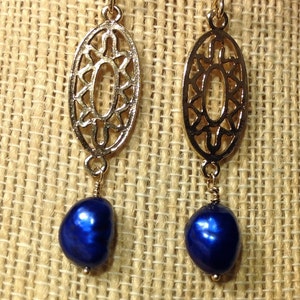 May include: Gold filigree earrings with a dangling blue pearl drop.