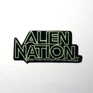 May include: Black and green embroidered patch with the text "Alien Nation" and the copyright information "©1990 Twentieth Century Fox Film Corp."