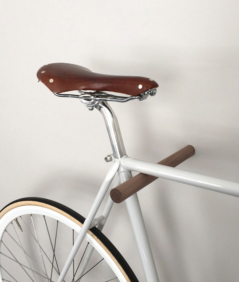 This pair of wooden bike hooks comes in black walnut wood. The wall mounted hooks hold a minimalistic sports bike in light grey. Only recommended for bicycles up to 13 kg.