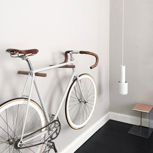 These minimal wooden bike hooks present an elegant and clever way to store your bespoke bicycle at home. Conceived as a piece of high-quality furniture rather than a mere practical device they offer a simple but sophisticated storage solution.