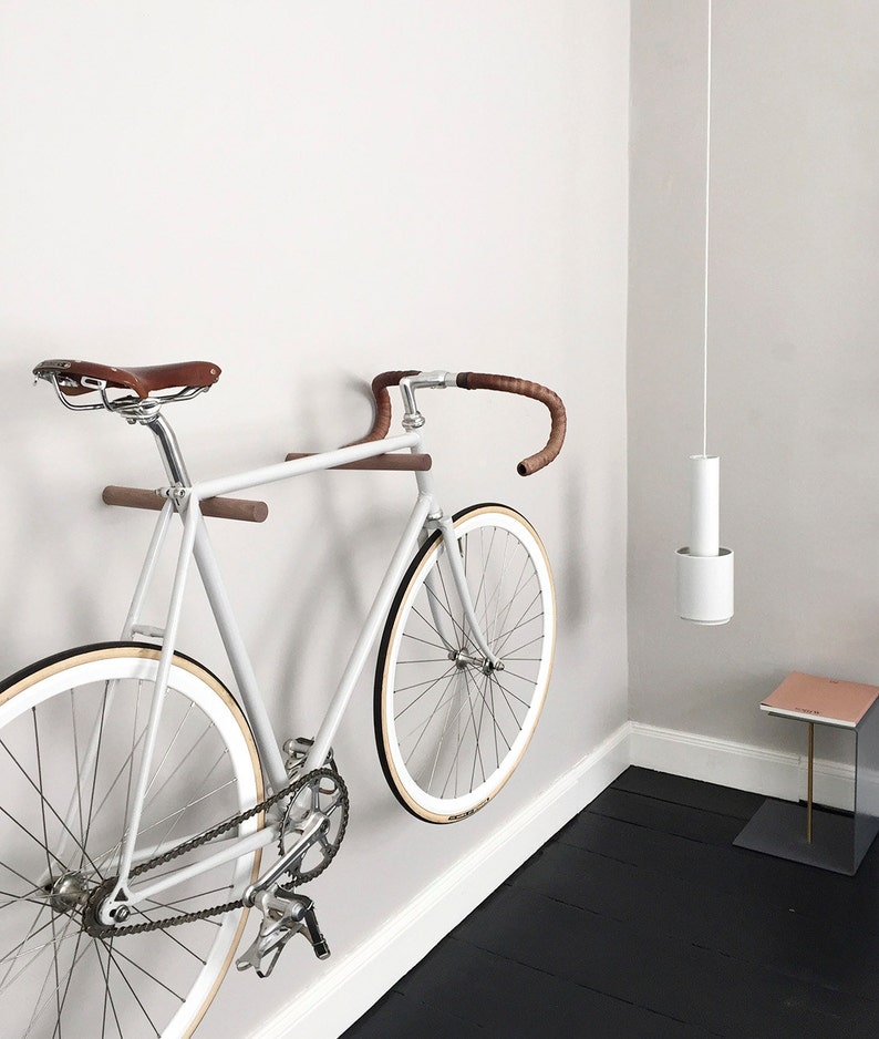 These minimal wooden bike hooks present an elegant and clever way to store your bespoke bicycle at home. Conceived as a piece of high-quality furniture rather than a mere practical device they offer a simple but sophisticated storage solution.