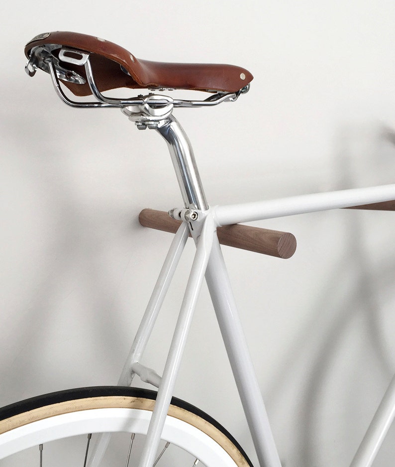 This pair of wooden bike hooks comes in black walnut wood. The wall mounted hooks hold a minimalistic sports bike in light grey. Only recommended for bicycles up to 13 kg.