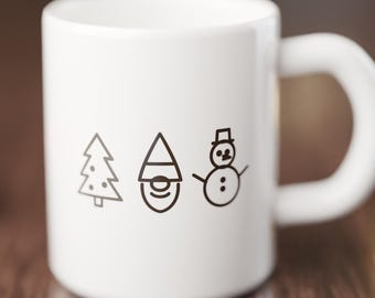 May include: A white ceramic mug featuring three black line art icons centered on the front: a stylized Christmas tree, a gnome wearing a pointed hat, and a snowman with a top hat and stick arms. The mug has a smooth finish and a handle.
