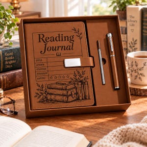 May include: A brown leather-like reading journal set in a matching box, featuring a book stack illustration and text fields for title, author, dates, and rating. The set includes a matching brown pen and a thin metal stylus, all encased in a box.