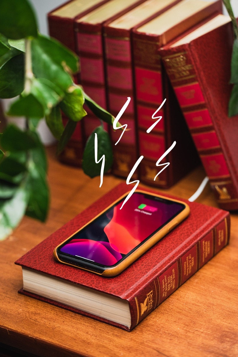 A phone on top of a red book shaped wireless charger