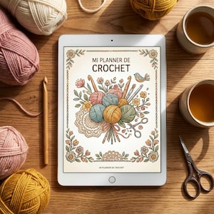 Puede incluir: Una tableta que muestra una portada digital titulada MI PLANNER DE CROCHET, con una ilustración de ovillos de lana, ganchillos, flores y un pájaro. La tableta está rodeada de ovillos, un ganchillo de madera y tijeras.