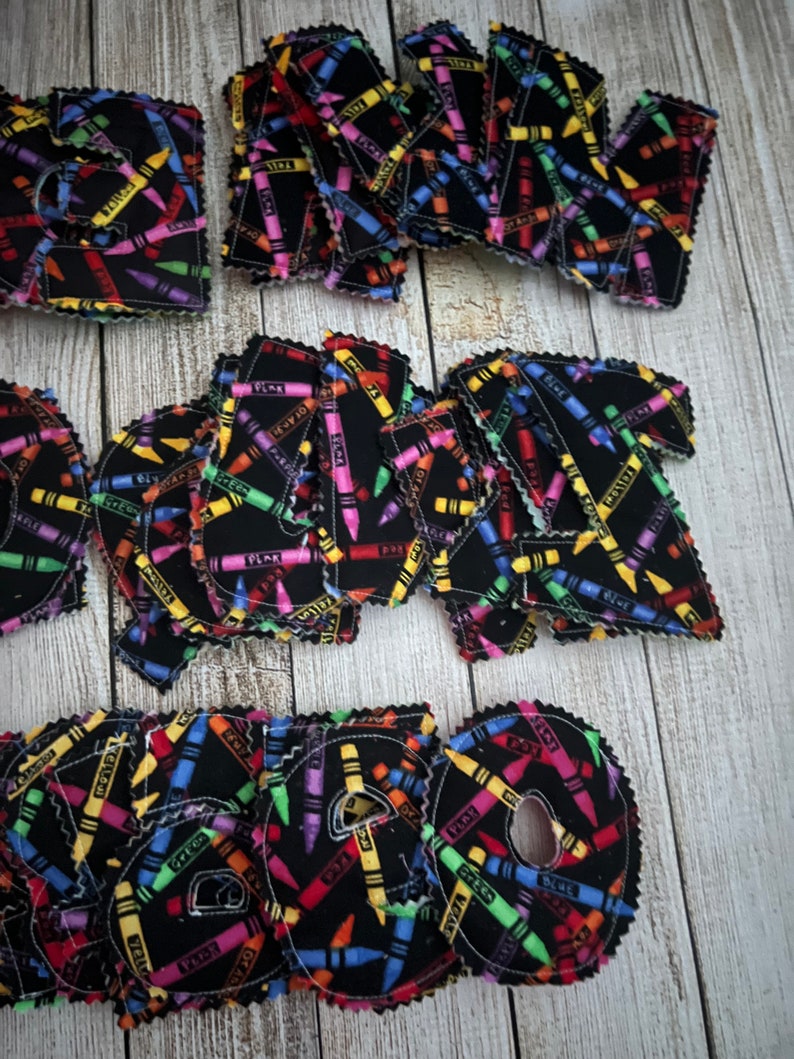 Pode incluir: Um conjunto de letras do alfabeto de feltro com um padr&atilde;o de giz de cera sobre um fundo preto. As letras est&atilde;o em mai&uacute;sculas e est&atilde;o dispostas em uma ordem aleat&oacute;ria.