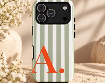 Puede incluir: Una funda para smartphone con un patrón de rayas verticales en verde salvia y blanco, que presenta una letra A mayúscula grande, en negrita y de color naranja, seguida de un punto en la parte inferior.