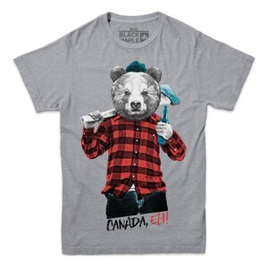 May include: A gray t-shirt with a cartoon bear wearing a plaid shirt, a blue hat, and holding an axe and a bottle of beer. The text "CANADA, EH!" is printed on the shirt.