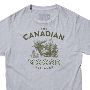 May include: A light gray t-shirt with a green moose graphic and the text "The Canadian Moose Alliance".