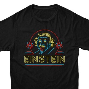 May include: Black t-shirt featuring a neon graphic of Albert Einstein with his tongue sticking out. The graphic is surrounded by neon atoms and the word "EINSTEIN" is written in neon letters below the graphic.