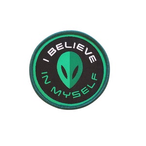 May include: Green and black embroidered patch with the text "I Believe in Myself" and a green alien head in the centre.
