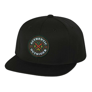 May include: Black and green embroidered patch on a black baseball cap. The patch features the words "Authentic Outsider" in a circle with a crossed axe and tent design.