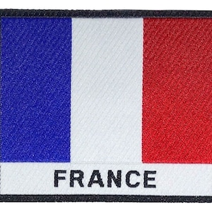 Peut inclure: Un patch en tissu bleu, blanc et rouge avec le mot "FRANCE" imprimé en noir sous le drapeau.