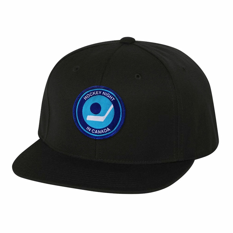 Puede incluir: Gorra de b&eacute;isbol negra con un parche bordado azul y blanco que dice "Hockey Night in Canada".