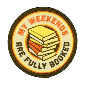 May include: A brown and orange round patch with the text "My Weekends Are Fully Booked" and a stack of yellow and orange books.