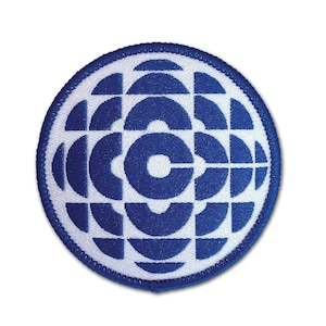 May include: An embroidered patch featuring the iconic CBC logo, a stylised globe with a white "C" in the centre.