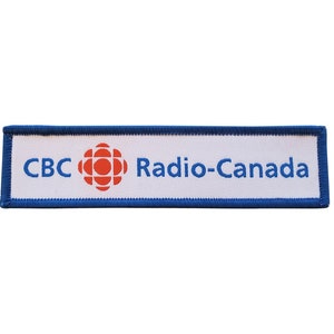 May include: White rectangular patch with blue edging. The patch has the text "CBC Radio-Canada" in blue lettering and a red and white stylised logo.