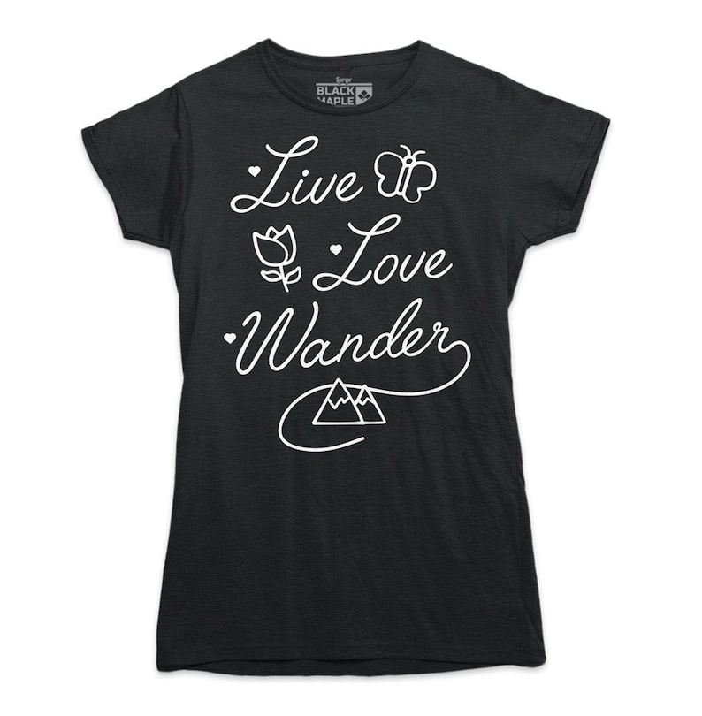 K&ouml;nnte beinhalten: Schwarzes T-Shirt mit wei&szlig;em Text "Live Love Wander" mit einem Schmetterling, einer Blume und einem Bergmotiv.