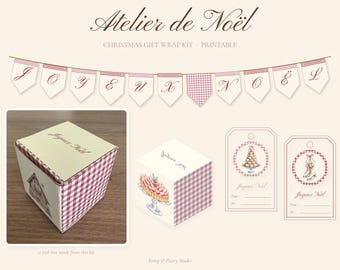 Puede incluir: Un kit de envoltorio de regalo navideño imprimible titulado Atelier de Noël que incluye una guirnalda con el texto Joyeux Noël, una caja cuadrada con laterales de cuadros rojos y un pastel, y dos etiquetas con ilustraciones.